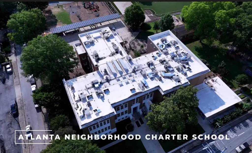 Aerial view of school building with playground.